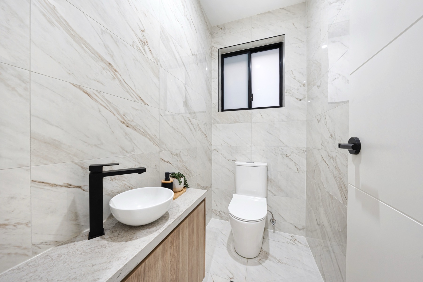 Sydney TCE bathroom detail with marble-look finishes and black fixtures